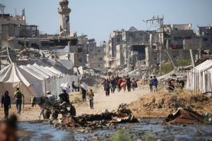 palestinos-desplazados-caminan-junto-a-carpas-y-RJOZ6TBI6RFEBBPCHJD7VHMLEE.JPG