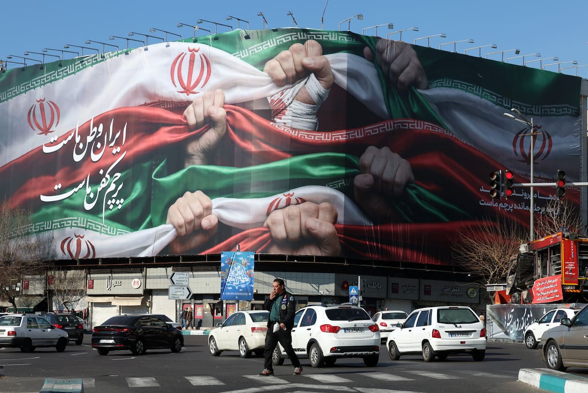 iranies-caminan-junto-a-un-cartel-publicitario-QE3IBUUB3NGRXMFYVXVWO5YWPU.JPG