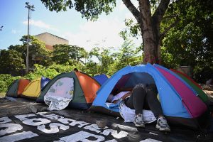 una-mujer-descansa-en-una-carpa-instalada-frente-EOVGHFMBWZD75MB22G3OGOKYQI.JPG