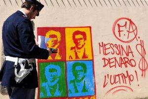 un-policia-mira-un-graffitti-con-la-imagen-y-el-LNQMICPPIJC3DMH5E6FGUHBE3Q.JPG